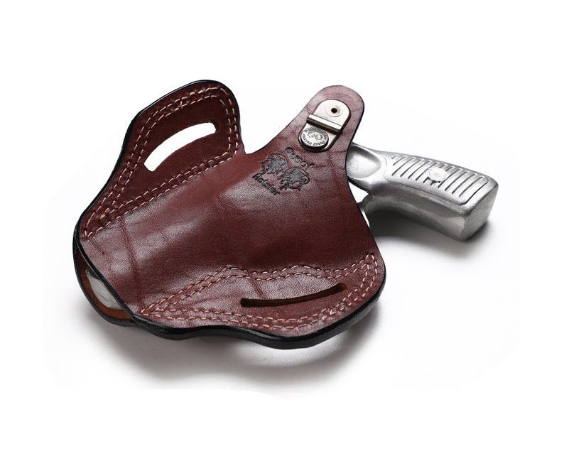 Puede incluir: Una funda de cuero marr&oacute;n con un rev&oacute;lver plateado en su interior. La funda tiene un cintur&oacute;n y un cierre de presi&oacute;n.