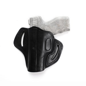 Puede incluir: Una funda de cuero negra para una pistola. La funda tiene un bucle para el cintur&oacute;n y un cierre a presi&oacute;n. La funda est&aacute; dise&ntilde;ada para adaptarse a una pistola compacta o subcompacta.