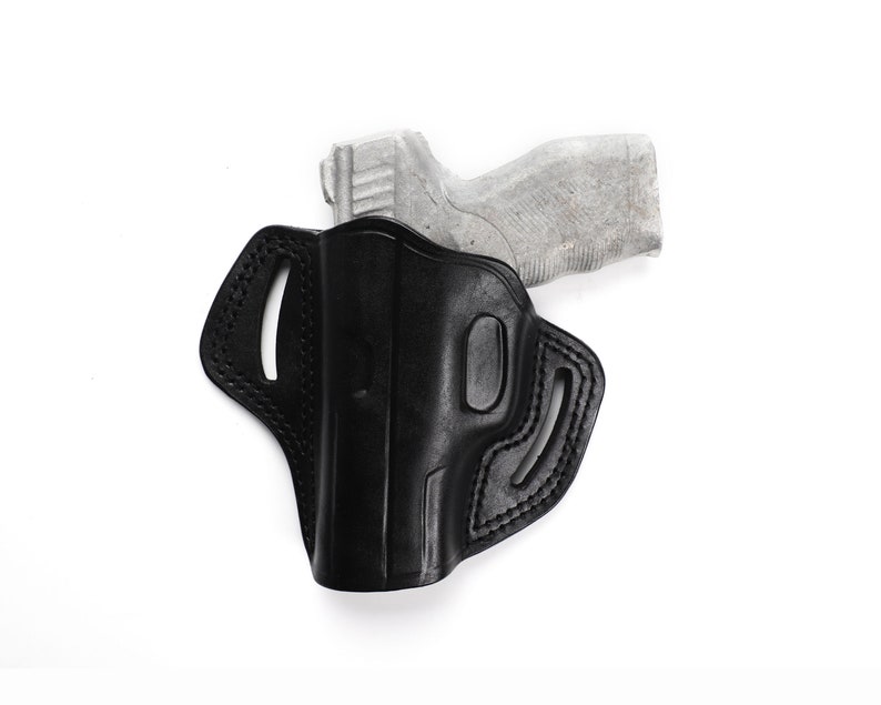 Puede incluir: Una funda de cuero negra para una pistola. La funda tiene un bucle para el cintur&oacute;n y un cierre a presi&oacute;n. La funda est&aacute; dise&ntilde;ada para adaptarse a una pistola compacta o subcompacta.