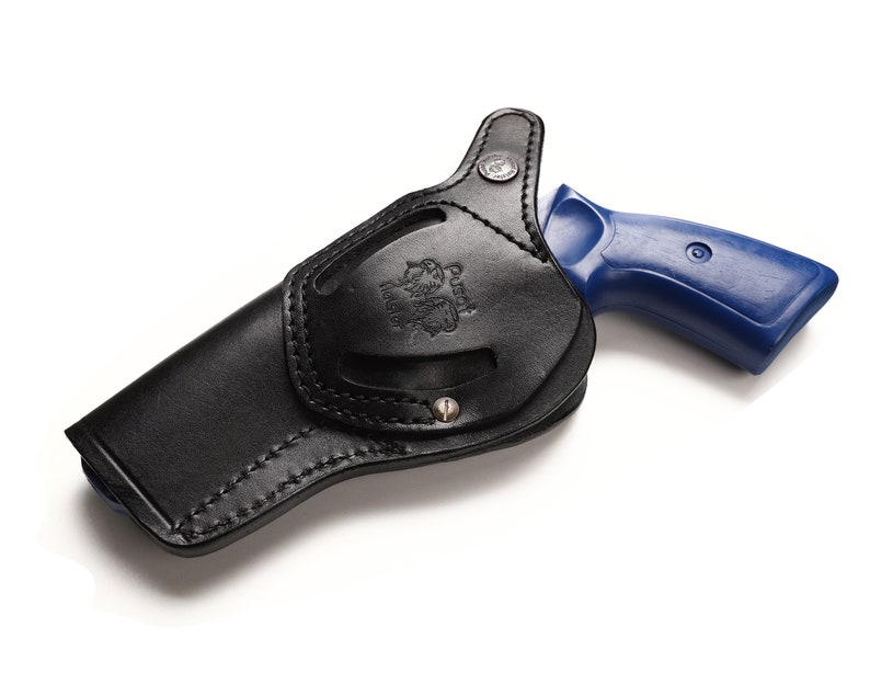 May include: A black leather holster with a blue revolver inside. The holster has a stitched design and a metal button.