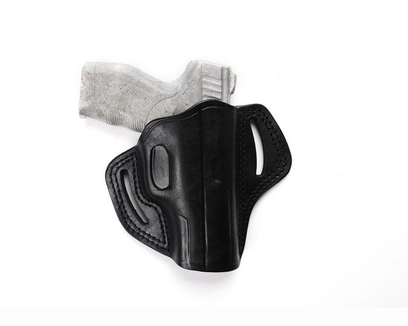 Puede incluir: Una funda de cuero negra para una pistola. La funda tiene un bucle para el cintur&oacute;n y un cierre a presi&oacute;n.