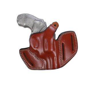 May include: A brown leather holster with a stitched design. The holster is designed to hold a small revolver.