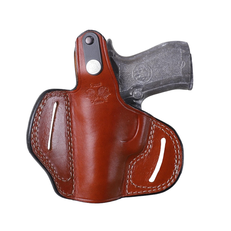 Handmade brown Right Hand leather OWB pancake holster by Pusat Holster, precision-molded for Beretta 84, 84BB, 84F, and 84FS Cheetah .380 ACP models. The image highlights the 100% premium genuine leather texture, hand-polished edges, and heavy-duty stitching on a white background. Features a secure thumb break with durable brass snaps and 304 stainless steel hardware. Designed for a perfect, rattle-free fit, offering a blend of classic style and tactical durability for daily carry.