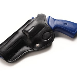 May include: A black leather holster for a blue handgun. The holster has a flap that covers the trigger guard.