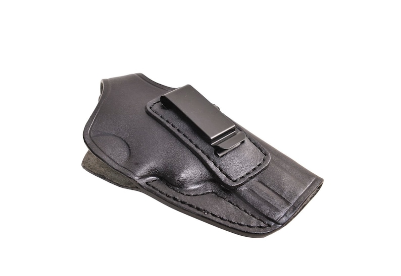 May include: Black leather holster with a metal clip. The holster is designed to hold a handgun. The leather is stitched around the edges. The clip is attached to the top of the holster.