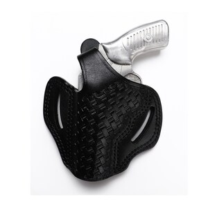 May include: A black leather holster with a woven pattern for a silver handgun.