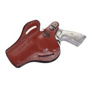 May include: A brown leather holster with a silver revolver inside. The holster has a stitched design and the text "Ruger" is visible on the side.