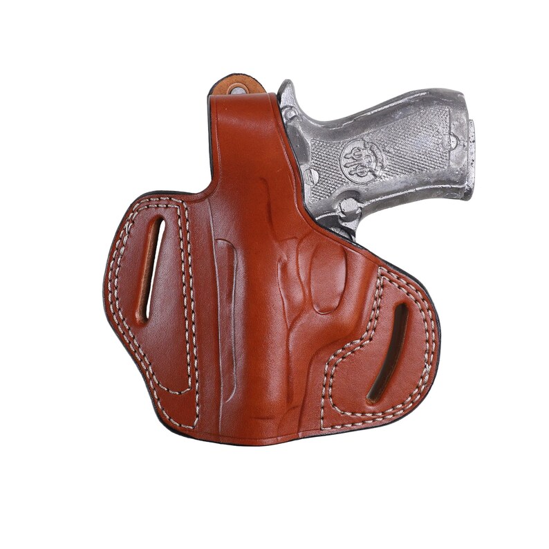 Handmade brown Left Hand leather OWB pancake holster by Pusat Holster, precision-molded for Beretta 84, 84BB, 84F, and 84FS Cheetah .380 ACP models. The image highlights the 100% premium genuine leather texture, hand-polished edges, and heavy-duty stitching on a white background. Features a secure thumb break with durable brass snaps and 304 stainless steel hardware. Designed for a perfect, rattle-free fit, offering a blend of classic style and tactical durability for daily carry.