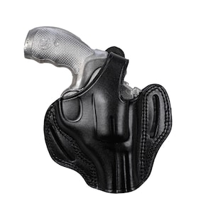 Może przedstawiać: Czarna skórzana kabura do rewolweru. Kabura ma pętlę na pasek i zapięcie na zatrzask.