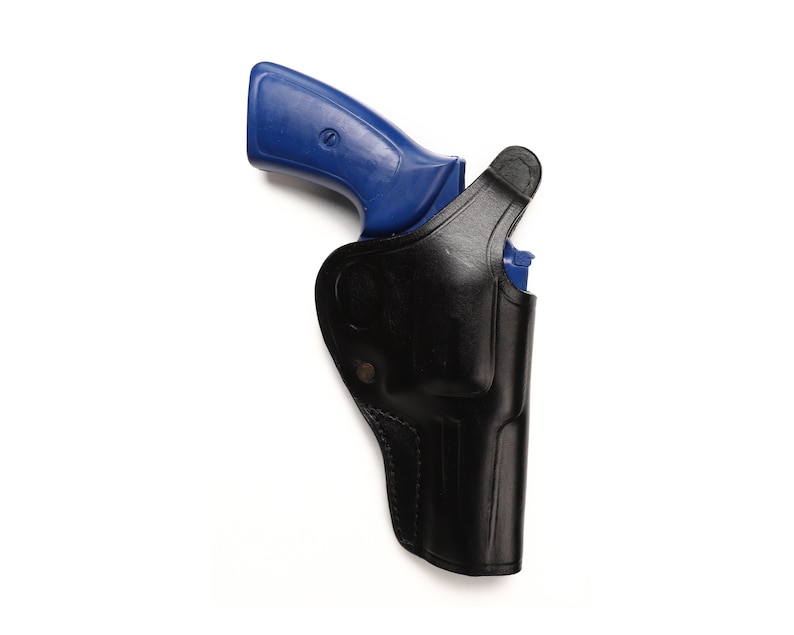 May include: A blue handgun in a black leather holster. The holster has a flap that covers the trigger guard.