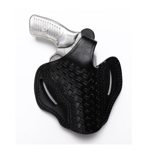 May include: A black leather holster with a woven pattern for a silver handgun.