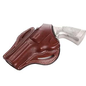 May include: A brown leather holster with white stitching for a revolver. The holster is designed to be worn on the belt.