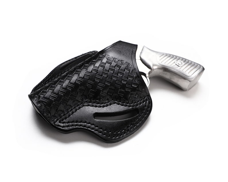 May include: A black leather holster with a woven pattern for a silver revolver.