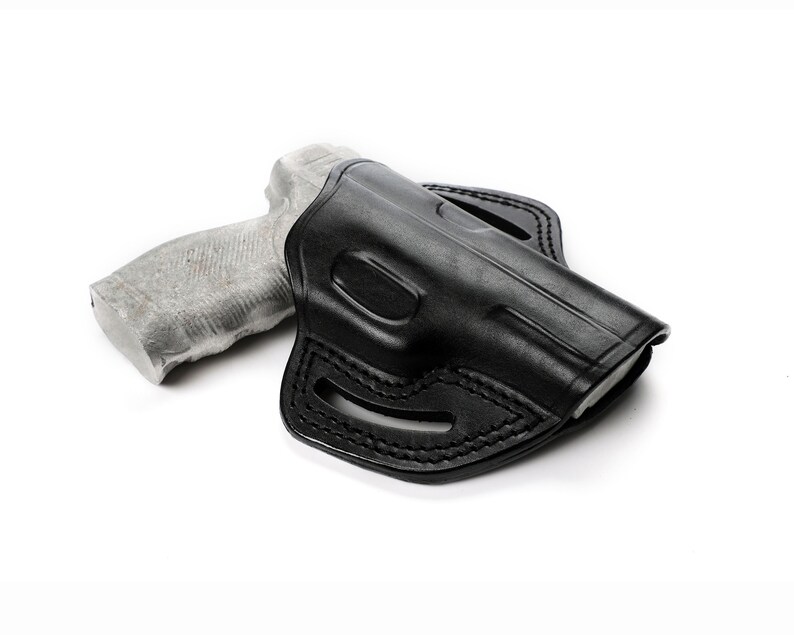 Puede incluir: Una funda de cuero negra para una pistola. La funda tiene un bucle para el cintur&oacute;n y un cierre a presi&oacute;n.