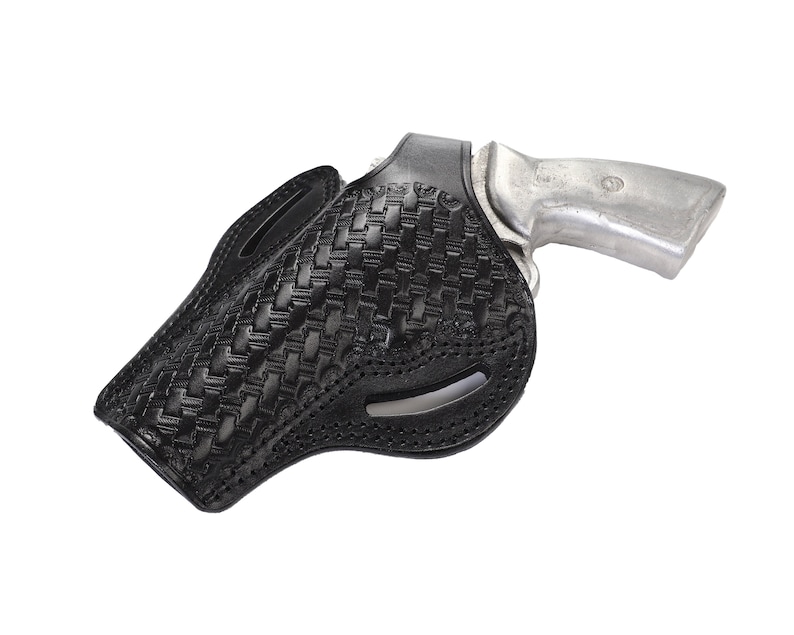May include: A black leather holster with a woven pattern for a silver handgun.