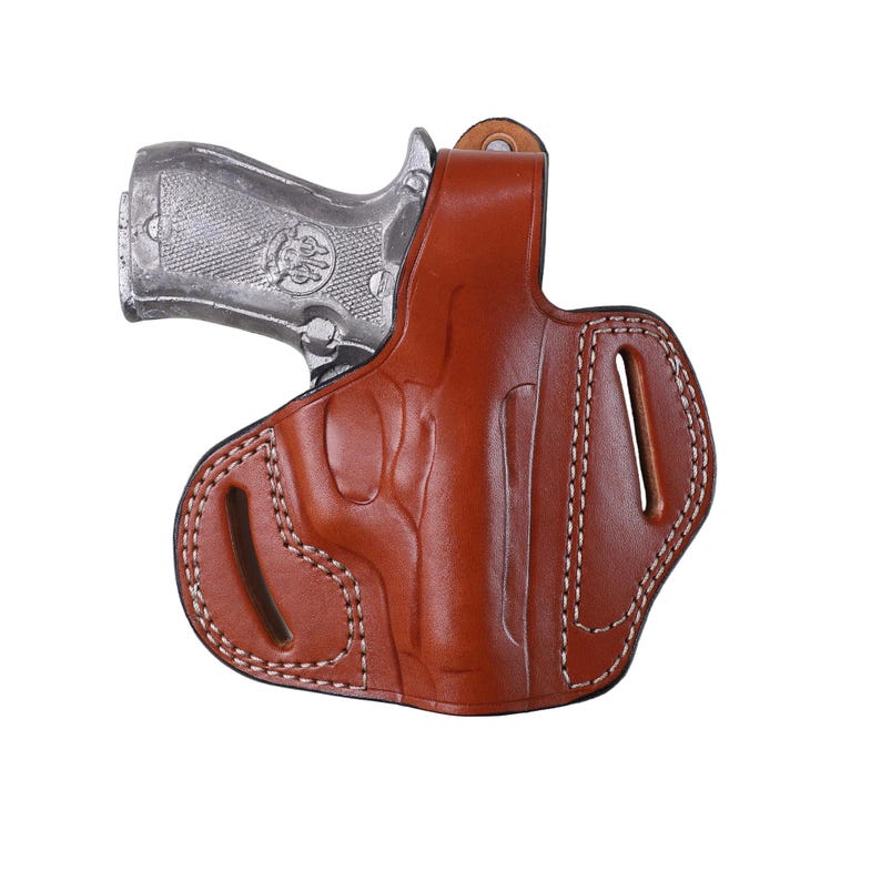 Handmade brown Right Hand leather OWB pancake holster by Pusat Holster, precision-molded for Beretta 84, 84BB, 84F, and 84FS Cheetah .380 ACP models. The image highlights the 100% premium genuine leather texture, hand-polished edges, and heavy-duty stitching on a white background. Features a secure thumb break with durable brass snaps and 304 stainless steel hardware. Designed for a perfect, rattle-free fit, offering a blend of classic style and tactical durability for daily carry.