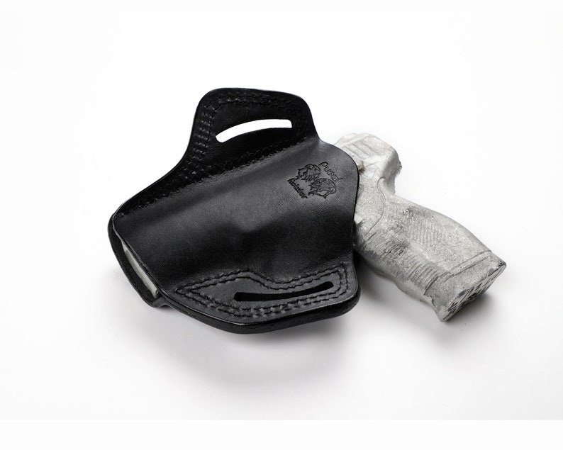 Puede incluir: Funda de cuero negro para una pistola. La funda tiene un bucle para el cintur&oacute;n y un protector del gatillo. La funda est&aacute; dise&ntilde;ada para llevarse en la cadera.