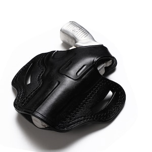Puede incluir: Una funda de cuero negra para una pistola. La funda tiene un dise&ntilde;o cosido y un recorte para el guardamonte.