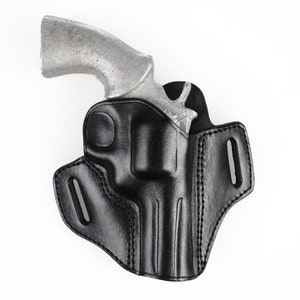 Puede incluir: Una funda de cuero negra para un revólver plateado.