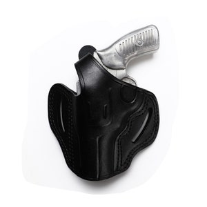 Puede incluir: Una funda de cuero negra con una pistola plateada en su interior. La funda tiene detalles de costura y un bucle para el cintur&oacute;n.