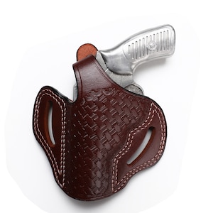 May include: A brown leather holster with a woven pattern and white stitching. The holster is designed to hold a small silver handgun.