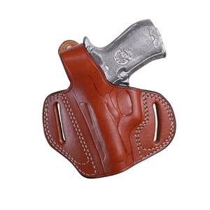 Handmade brown Left Hand leather OWB pancake holster by Pusat Holster, precision-molded for Beretta 84, 84BB, 84F, and 84FS Cheetah .380 ACP models. The image highlights the 100% premium genuine leather texture, hand-polished edges, and heavy-duty stitching on a white background. Features a secure thumb break with durable brass snaps and 304 stainless steel hardware. Designed for a perfect, rattle-free fit, offering a blend of classic style and tactical durability for daily carry.