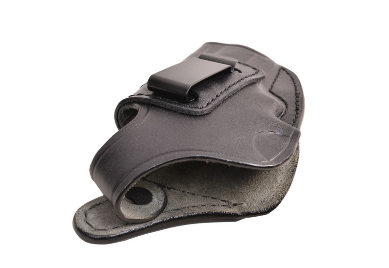 May include: Black leather holster with a metal clip. The holster is designed to be worn on the inside of the waistband. The interior is a lighter shade of gray. The holster is made of a durable material.
