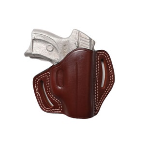 May include: A brown leather holster with white stitching and a silver handgun. The holster has a molded shape and open top, with a belt loop design. The handgun is partially visible, resting inside the holster.