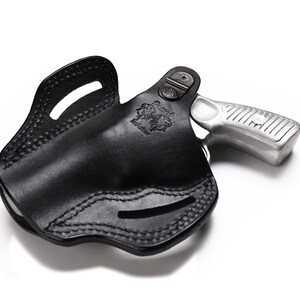 May include: A black leather holster with a silver revolver inside. The holster has a stitched design and a belt loop.