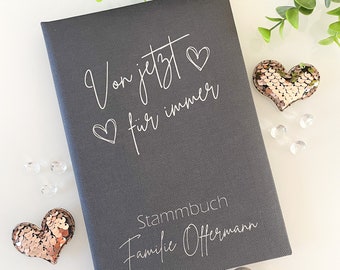 Op de afbeelding: Een grijs boek met een stoffen omslag met de tekst "Von jetzt für immer" en een hartje. Het boek heeft ook de tekst "Stammbuch Familie Offermann".