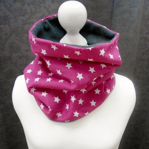 Könnte beinhalten: Ein rosa-weißer Sternmuster-Halswärmer mit grauem Fleece-Futter.