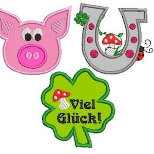 May include: Three embroidered patches with a pink pig face, a gray horseshoe with red dots and a green four-leaf clover with the text "Viel Glück!" in black.
