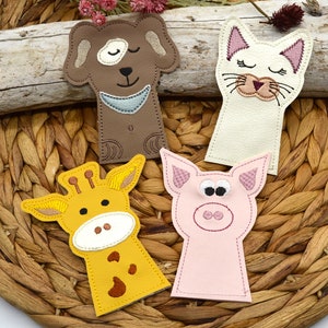May include: Four finger puppets made of felt, each with a different animal face. The puppets are brown, white, yellow, and pink. The animals are a dog, a cat, a giraffe, and a pig.