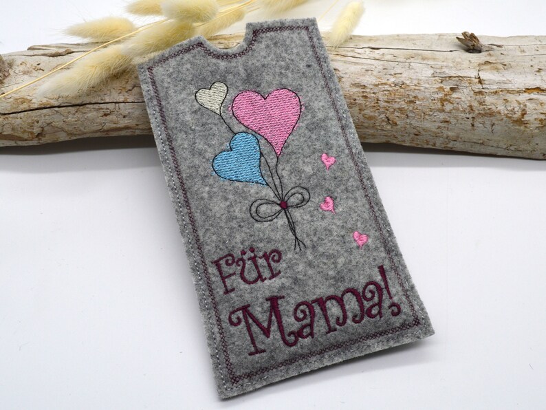 May include: A gray felt card with a pink, blue, and white heart balloon design. The card says "F&uuml;r Mama!" in burgundy embroidery.