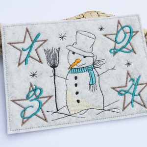 May include: A white felt Christmas advent calendar with a snowman holding a broom. The numbers 1, 2, 3, and 4 are embroidered in teal on brown stars.