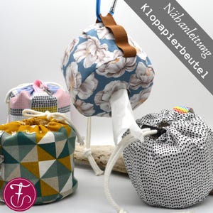 Könnte beinhalten: Eine Sammlung von Stoffbeuteln mit Kordelzug in verschiedenen Mustern und Farben. Eine Tasche ist blau mit weißem Blumendruck, eine andere rosa und Patchwork, und eine dritte grün und gelb geometrisch. Die Taschen hängen und liegen auf einer weißen Oberfläche.