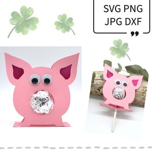 Peut inclure: Cochon en papier rose avec des yeux globuleux et un trou pour un baiser au chocolat. Le cochon est debout sur une surface plane. SVG PNG JPG DXF.
