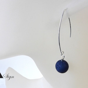 Può includere: Un paio di orecchini pendenti in argento con una perla rotonda blu scuro su ogni orecchino.