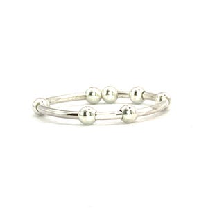 Könnte beinhalten: Ein silbernes Armband mit Perlen und einem doppelten Band.