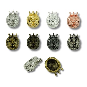 Op de afbeelding: Assortiment van leeuwenkopcharms met een kroon, verkrijgbaar in zilver, goud, zwart en koper. De charms zijn gedetailleerd met een leeuwenkop en een kroon bovenop.