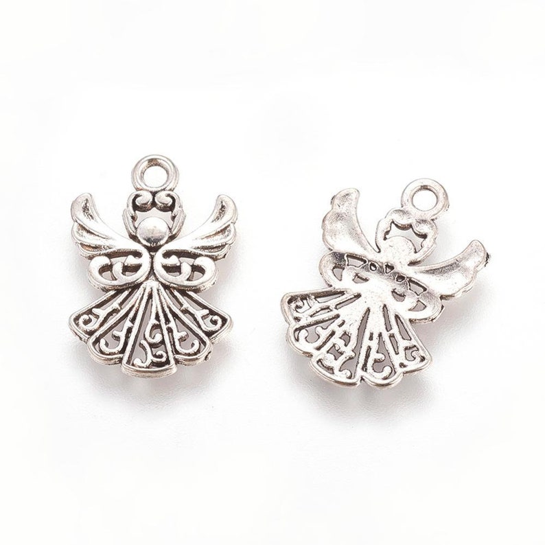 Puede incluir: Dos encantos de &aacute;ngel de plata con intrincados dise&ntilde;os de filigrana. Los encantos son perfectos para agregar un toque de elegancia a las joyas o las manualidades.