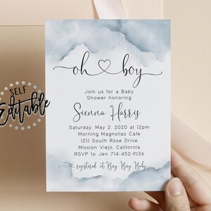 May include: A baby shower invitation with a watercolor background in shades of blue. The invitation reads "oh boy" with a heart symbol and includes the name Sienna Harris, the date and time of the shower, the location, and the RSVP information. The invitation also includes the text "registered at Buy Buy Baby".