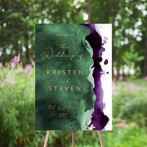 May include: Welcome to the wedding of Kristen and Steven, 23rd of March 2025. A green and purple watercolor wedding sign with gold lettering.