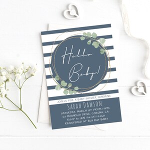 Puede incluir: Una invitaci&oacute;n a una fiesta de bienvenida al beb&eacute; a rayas azules y blancas con un c&iacute;rculo dorado y hojas verdes. El texto "Hello Baby!" est&aacute; escrito en blanco dentro del c&iacute;rculo. La invitaci&oacute;n incluye el nombre "Sarah Dawson" y los detalles de la fiesta de bienvenida al beb&eacute;.
