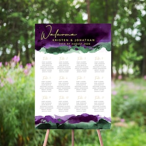 May include: A wedding seating chart with a purple and green watercolor background. The chart lists the names of guests assigned to each table. The text at the top reads "Welcome Kristen & Jonathan 20th of August 2020".