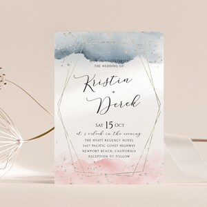 May include: Wedding invitation with a watercolor background in shades of blue and pink with gold glitter accents. The invitation features the names Kristin and Derek and the date Saturday, October 15th. The text reads "Join us to celebrate the wedding of Kristin + Derek, Sat 15 Oct at 5 o'clock in the evening, The Hyatt Regency Hotel, 5427 Pacific Coast Highway, Newport Beach, California, Reception to follow."