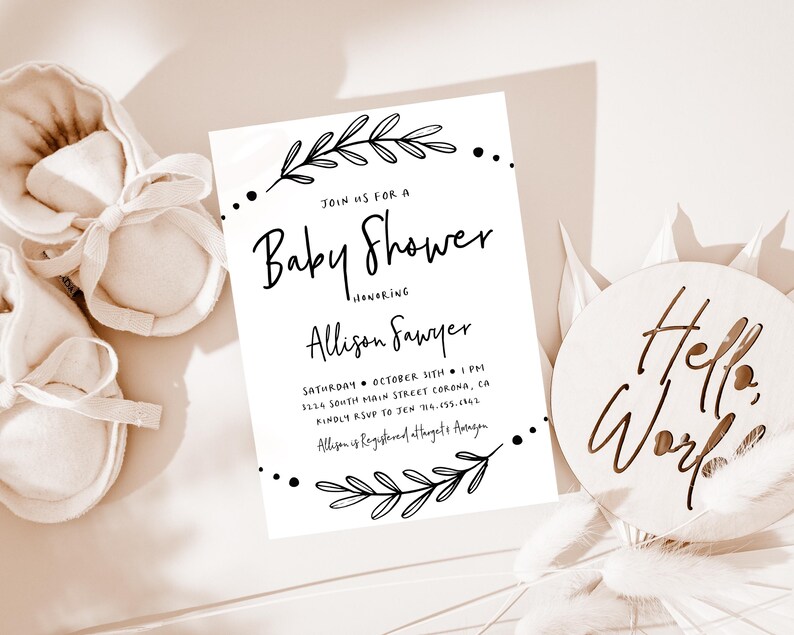 May include: A white baby shower invitation with black calligraphy text. The invitation reads "Join us for a Baby Shower honoring Allison Sawyer" and includes the date, time, and location of the event. The invitation is decorated with simple black floral illustrations.