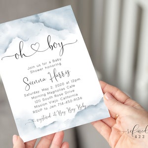 May include: A blue watercolor baby shower invitation with the text "oh boy" in cursive. The invitation includes the details of the shower, including the date, time, location, and RSVP information.