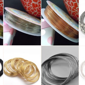 Könnte beinhalten: Eine Sammlung von Schmuckherstellungsbedarf, bestehend aus Spulen mit gold-, silber- und kupferfarbenem Draht sowie verschiedenen kreisförmigen Drahtketten in Schwarz, Gold und Silber, teilweise mit metallischen Endkappen und Verschlüssen.