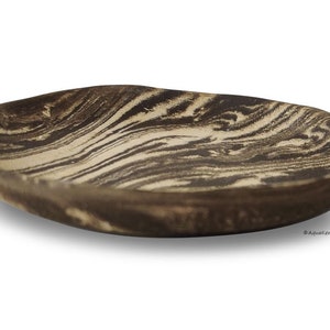 May include: A brown and white ceramic serving dish with a wavy, organic shape. The dish has a marbled pattern.